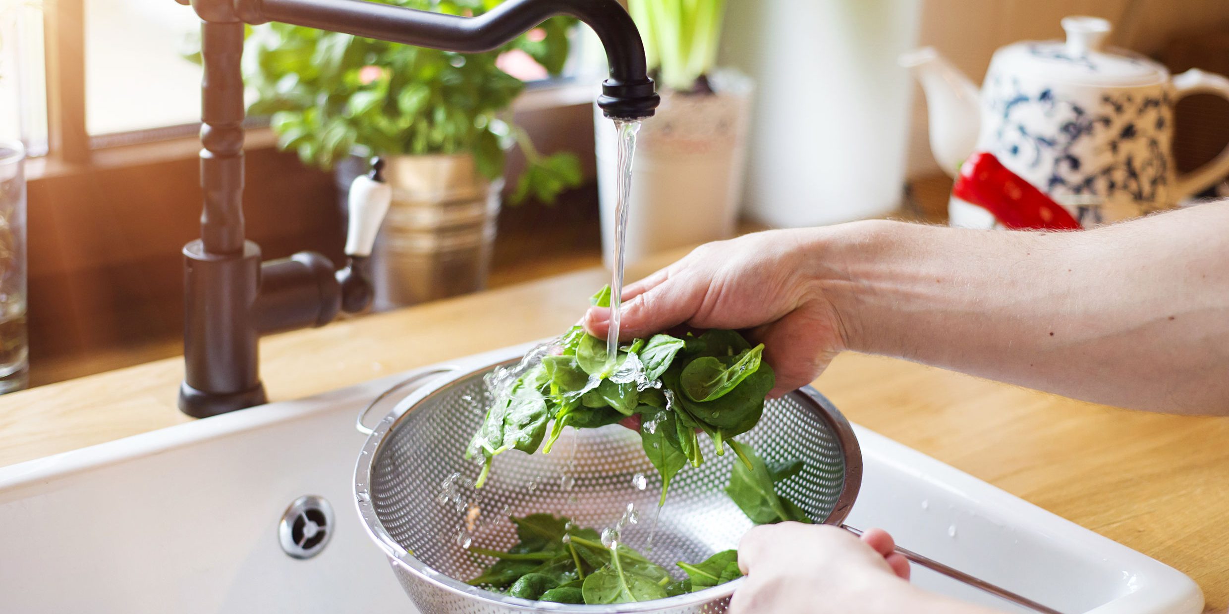 40802271 – unrecognizable man washing green salad leaves in the kitchen sink
