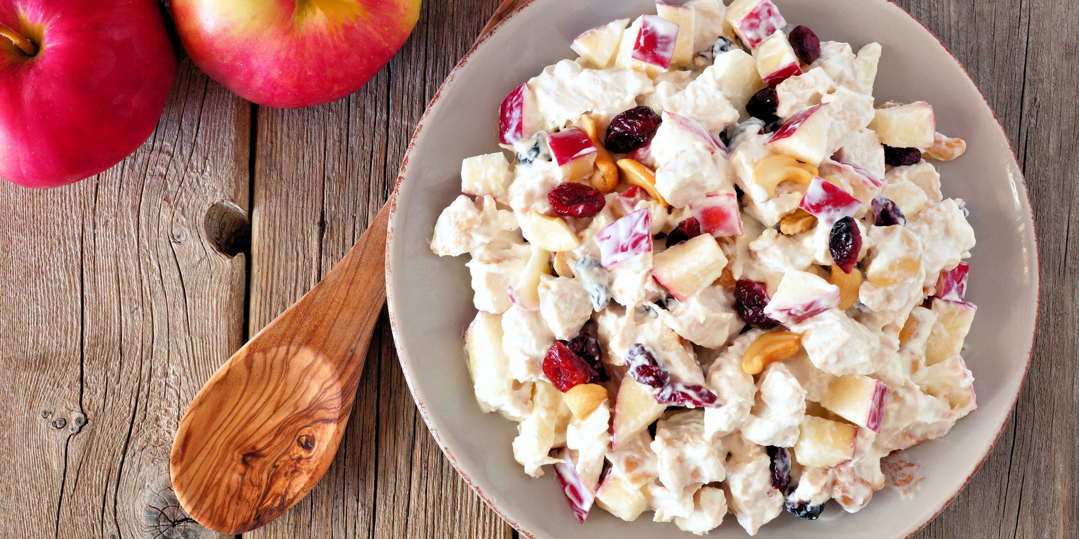 Autumn saladwith chicken, apples, nuts and cranberries, over wood